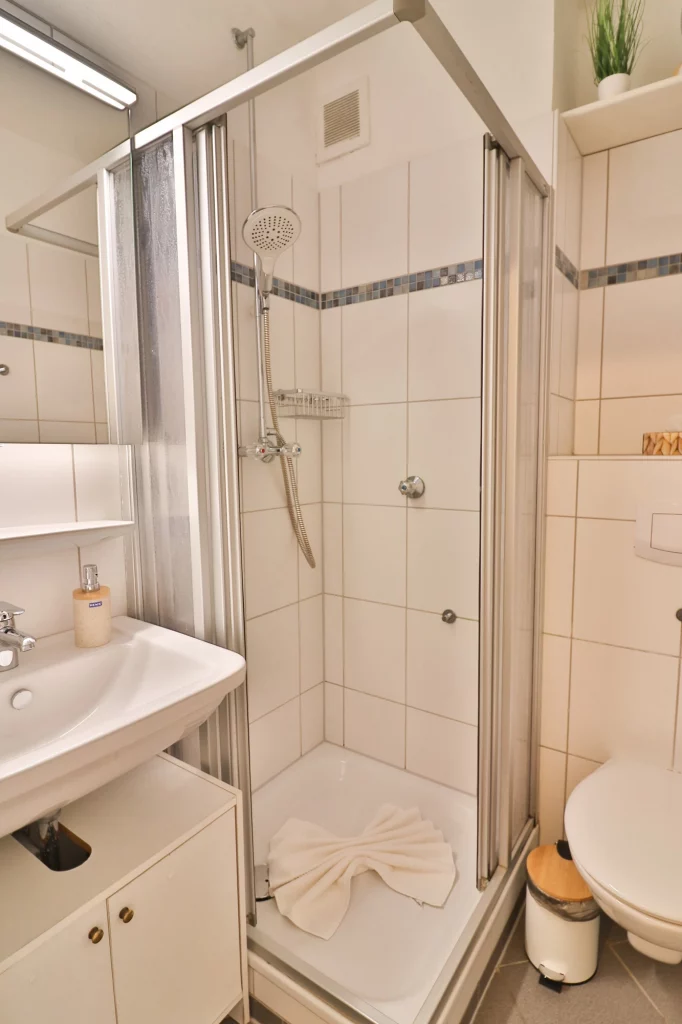 Das Badezimmer der Düne 53 Grad ist mit einem Spiegelschrank, einer Dusche und einer Handtuchheizung ausgestattet.